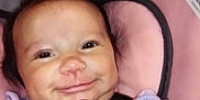 Ava Sherman is registered to the contest to win money with this photo: baby, car_seat, child, close_up, clothing, cute, face, hair, happy, indoors, infant, padded, person, pink, portrait, purple, safety, seat_belt, smiling, warning_label