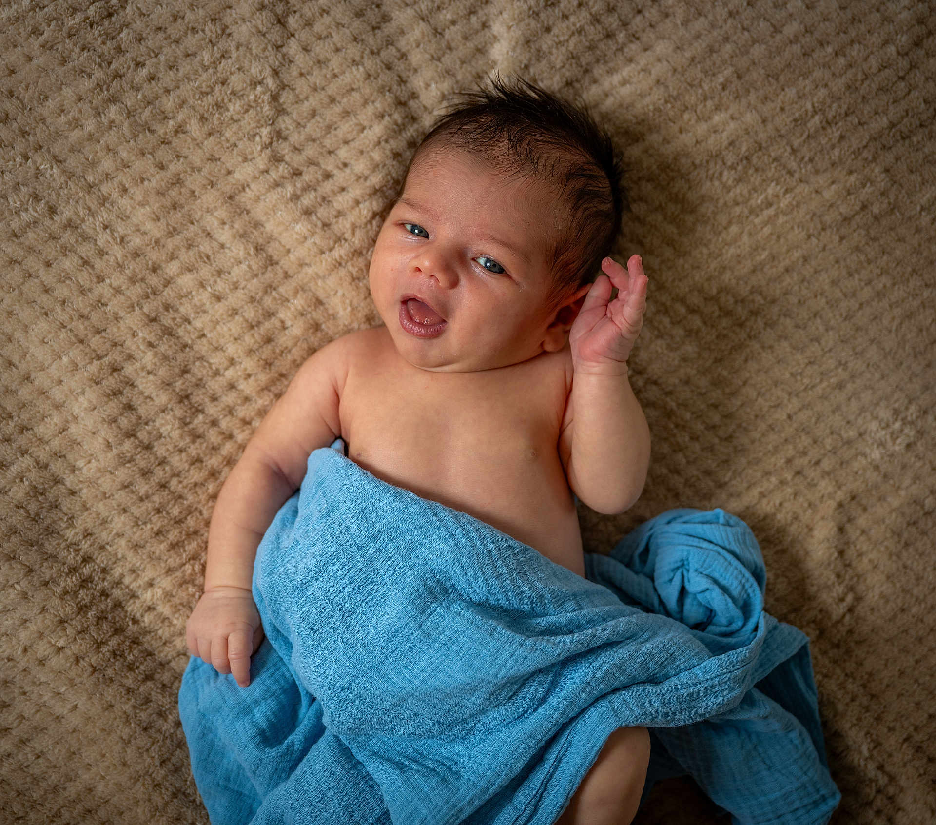 Viktor is registered to the contest to win money with this photo: baby, infant, blue_blanket, lying_down, curly_hair, expression, closeup, skin, child, cute, soft_texture, blanket, comfort, indoors, newborn, portrait, face, hand, eyes, resting