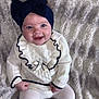 Myla is registered to the contest to win money with this photo: baby, child, smile, headband, bow, white_clothing, tights, sitting, blanket, texture, cute, happy, portrait, infant, cozy, soft, indoor, fashion, warm, baby_girl