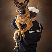 Koda Marie is registered to the contest to win money with this photo: dog, german_shepherd, sailor, uniform, pet, animal, portrait, studio, brown_background, happy, tongue_out, holding, person, back_view, military, friendship, companion, cute, ears_up, fur
