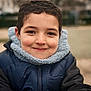 Haroun participe au concours pour gagner de l'argent avec cette photo : child, smiling, face, portrait, jacket, winter_clothing, outdoor, young, happy, curly_hair, closeup, person, warm, cute, casual, daylight, nature, childhood, friendly, fun