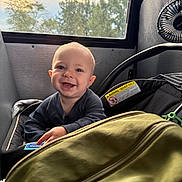 Lucas joined the competition — help win amazing prizes! baby, smile, child, car_seat, window, trees, sky, bag, indoor, seat, clothing, happy, person, face, infant, transportation, sunlight, hand, zipper, fan