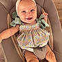 baby, child, smiling, headband, bow, floral_dress, blue_eyes, baby_chair, cushion, wooden_floor, happy, infant, sitting, cute, indoors, portrait, skin, person, clothing, closeup