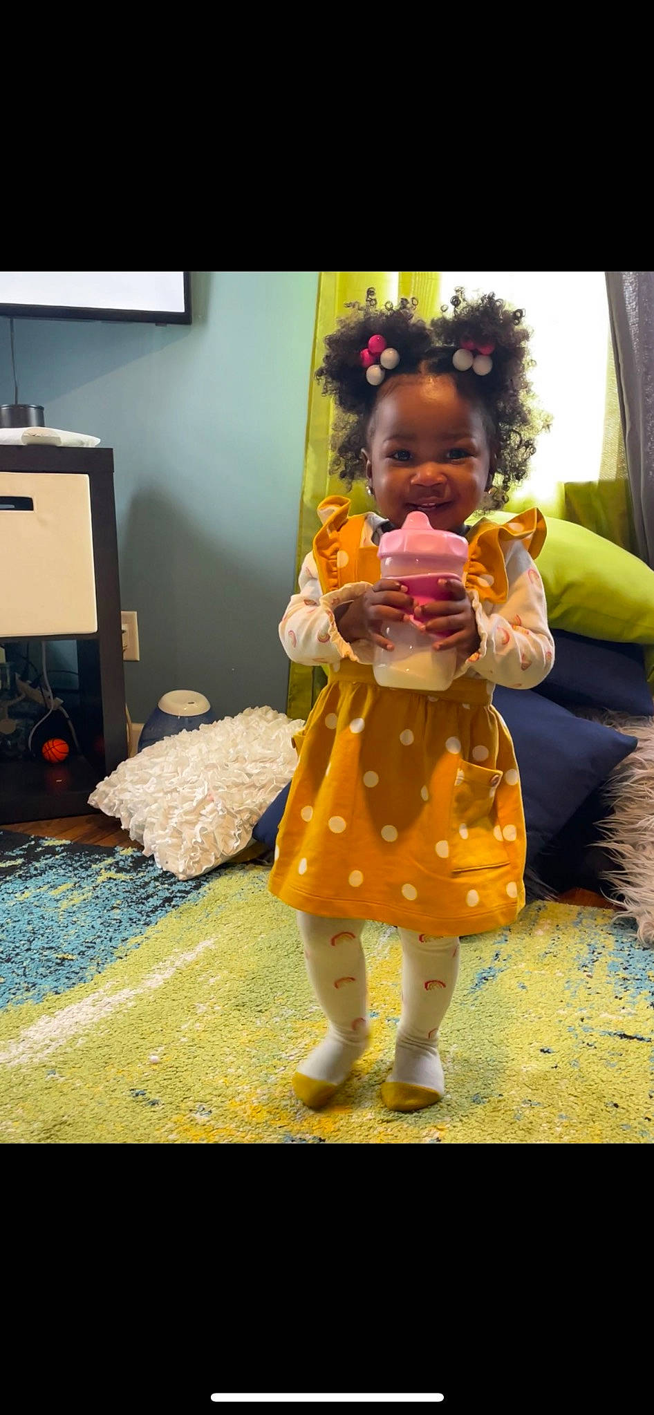 Zia is registered to the contest to win money with this photo: animation, chest_of_drawers, child, costume, event, flooring, fruit, fun, fur, happy, joy, orange, person, personal_protective_equipment, play, room, selfie, sitting, stuffed_toy, television