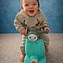 Julian a rejoint le concours — aidez-le/la à gagner de superbes lots ! baby, blue_wall, carpet, child, clothing, cute, expression, footwear, fun, happy, indoor, person, plastic_toy, playful, portrait, reindeer_outfit, scooter, smiling, toddler, toy