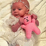Lyla is registered to the contest to win money with this photo: baby, infant, headband, butterfly, pink_toy, knitted_toy, white_dress, lace, sparkles, cute, newborn, soft_blanket, portrait, smiling, hand, face, eyes, lying_down, child, adorable