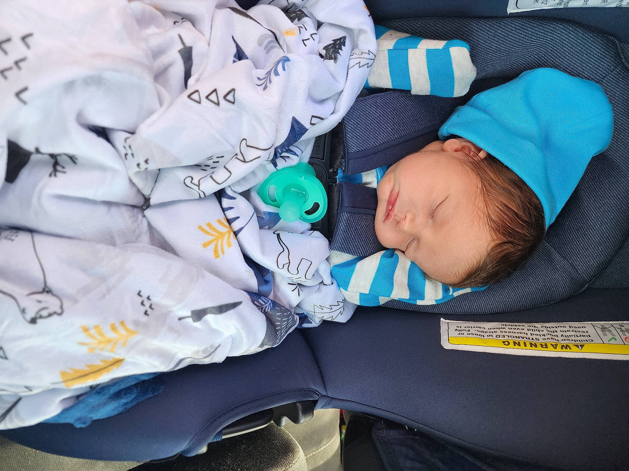 Josiah is registered to the contest to win money with this photo: auto_part, baby, baby_carriage, baby_products, baby_sleeping, baby_toddler_clothing, car_seat, child, comfort, electric_blue, font, linens, nap, pattern, person, product, sleep, sleeve, toddler, windshield