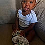 Infinity is registered to the contest to win money with this photo: baby, infant, child, sitting, couch, white_shirt, headband, sneakers, shoes, ribbons, curious, indoors, portrait, cute, small_hands, black_skin, comfortable, fabric, footwear, young