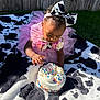 Infinity is registered to the contest to win money with this photo: toddler, child, cake, birthday, pink_tutu, headband, cow_print, bow, sprinkles, outdoor, grass, wooden_fence, blanket, celebration, curious, cute, colorful, party, one_year, smiling