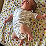 baby, infant, child, blanket, patterned_blanket, butterfly, bee, flower, onesie, clothing, lying_down, happy, looking_up, cute, newborn, skin, foot, hand, face, indoors