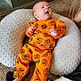 Eric joined the competition — help win amazing prizes! baby, carpet, child, cozy, cushion, face, floor, hand, happy, head, indoor, infant, lying_down, orange_clothing, pajamas, person, pumpkin_pattern, relaxed, smiling, soft_texture