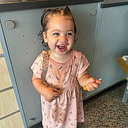 Jayley joined the competition — help win amazing prizes! toddler, child, smiling, indoor, pink_dress, wet_hair, pigtails, carpet, cabinet, countertop, purple_shoes, patterned_clothing, holding_object, happy, person, floor, playful, cute, young_child, standing