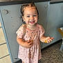Jayley joined the competition — help win amazing prizes! toddler, child, smiling, indoor, pink_dress, purple_shoes, pigtails, carpet, cabinet, holding, happy, cute, person, floor, clothing, hair, footwear, playful, young_child, standing