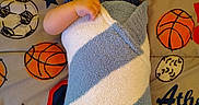 Brian joined the competition — help win amazing prizes! baby, infant, child, portrait, lying_down, blanket, swaddled, smiling, face, eyes, indoor, bed, bedding, sports_theme, basketball, football, stars, cozy, pointing, photography