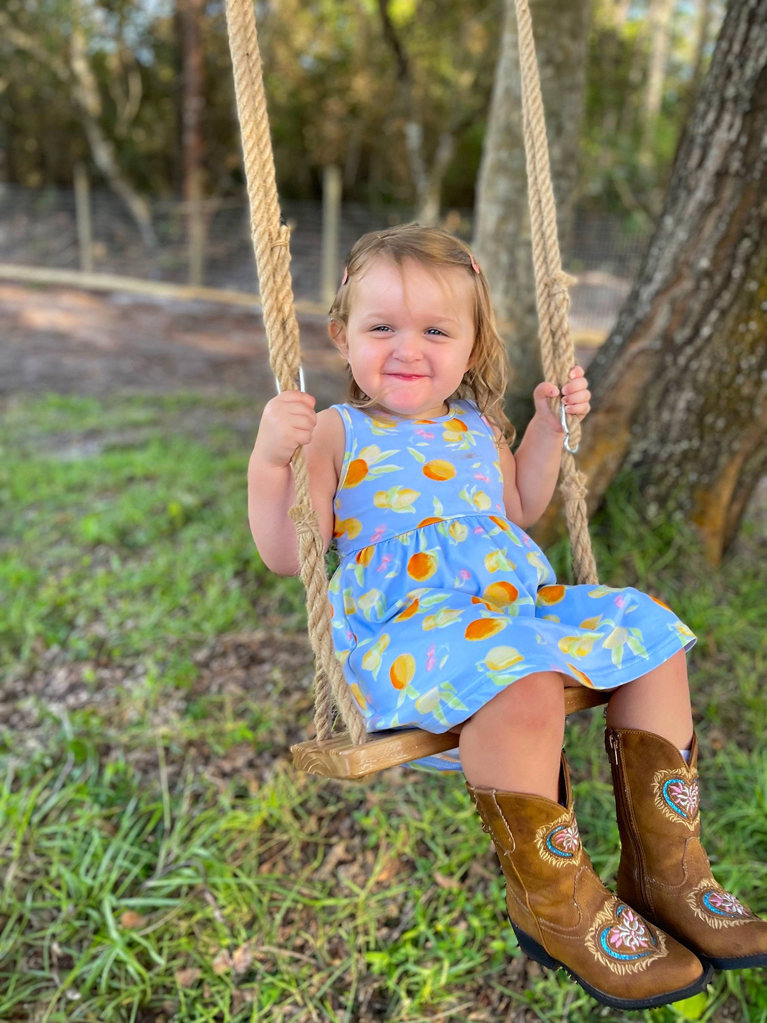Amelia is registered to the contest to win money with this photo: baby_toddler_clothing, child, electric_blue, eye, fun, grass, happy, head, joy, leisure, people_in_nature, person, plant, playground, skin, smile, swing, toddler, tree, wood