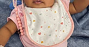 Nyielle is registered to the contest to win money with this photo: baby, baby_beads, bib, blanket, blue_blanket, casual_photo, child, close_up, diaper, indoor, infant, looking_at_camera, lying_down, pacifier, pink_clothing, portrait, smiling, soft_texture, white_hat, wide_eyes