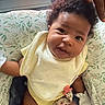 Nyielle is registered to the contest to win money with this photo: adult_hand, baby, baby_seat, bib, child, close_up, curious, curly_hair, cushion, family, floral_pattern, happy, indoor, infant, pacifier_clip, photography, portrait, sitting, smiling, tablet