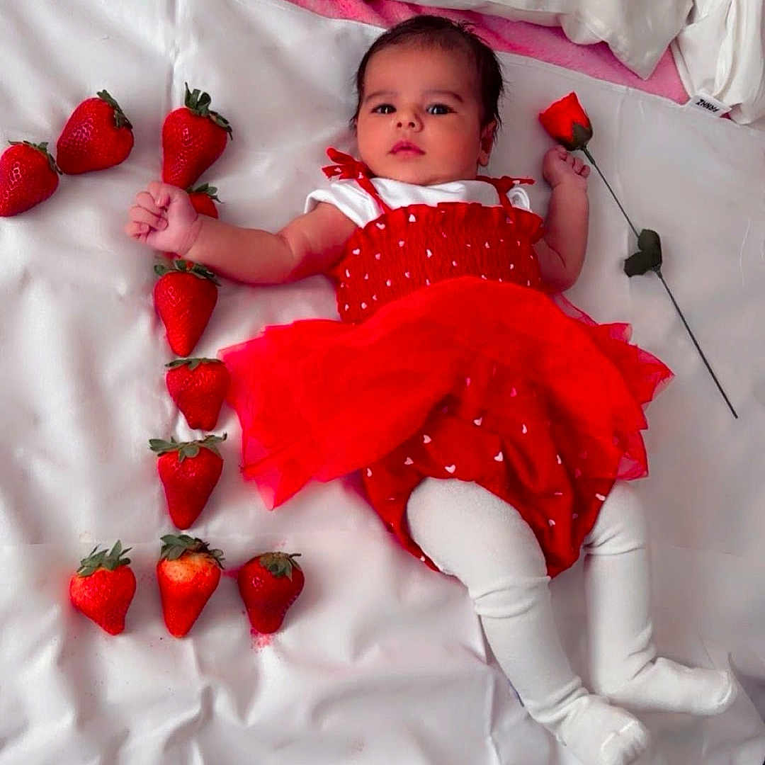 Ibadat Kaur joined the competition — help win amazing prizes! arrangement, baby, bed, child, cozy, cute, flower, fruit, indoor, infant, lying_down, pillows, portrait, red_dress, rose, soft_lighting, still_life, strawberries, white_bedspread, white_tights
