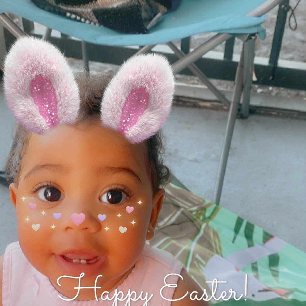 Olivia joined the competition — help win amazing prizes! toddler, child, girl, pink_dress, bunny_ears_filter, face_filter, hearts, sparkles, smiling, indoor, chair, blanket, mat, cute, easter, text_overlay, portrait, baby, person, happy