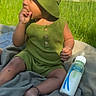 Kashton joined the competition — help win amazing prizes! baby, infant, green_clothing, bucket_hat, outdoor, grass, blanket, milk_bottle, sitting, thumb_sucking, bracelet, sunlight, cute, child, portrait, summer, nature, relaxed, casual, daytime