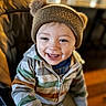 Zayne joined the competition — help win amazing prizes! toddler, child, smiling, hat, knit_hat, pom_poms, hoodie, striped_clothing, happy, indoor, portrait, face, blue_eyes, young_child, seated, warm_lighting, casual_clothing, cute, person, baby