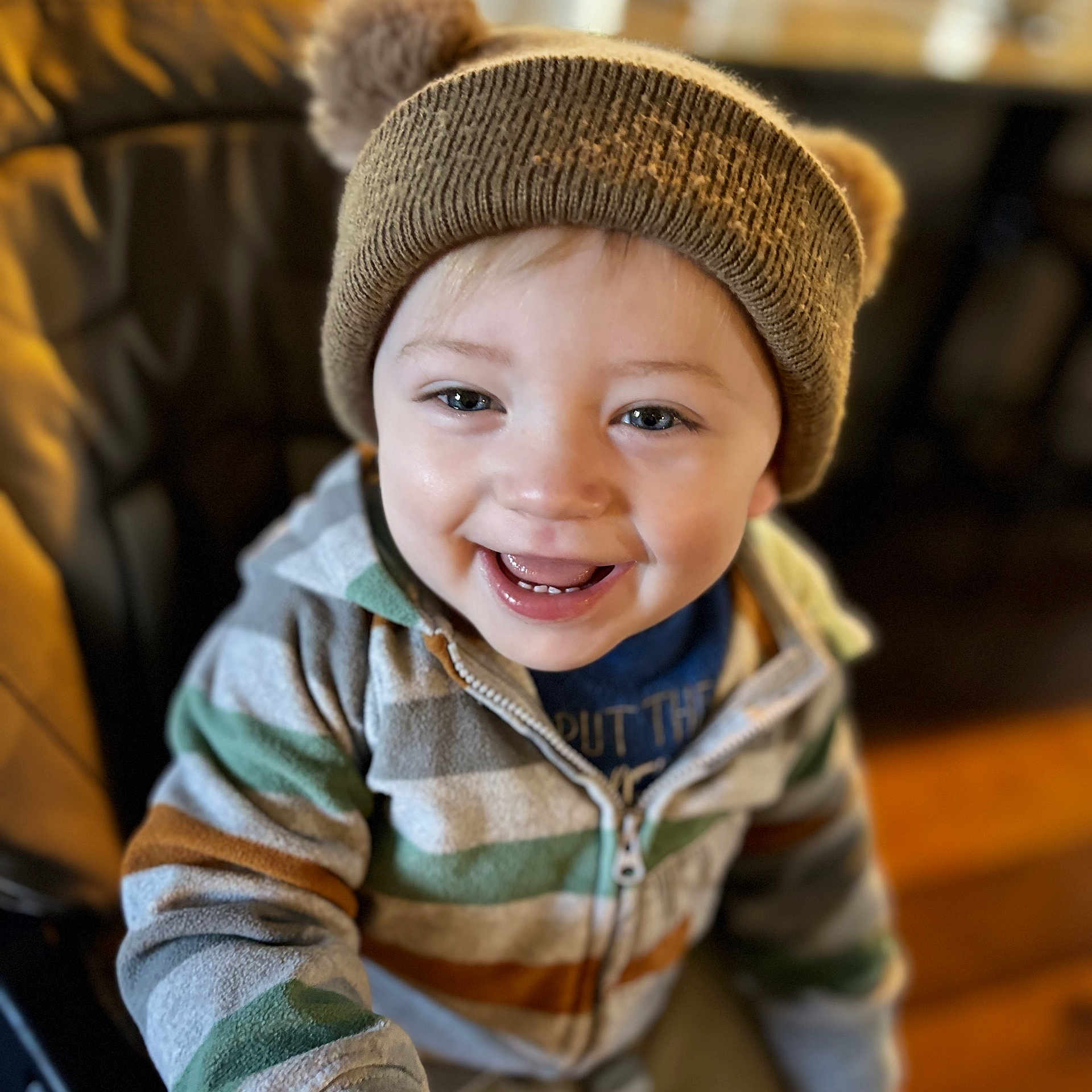 Zayne joined the competition — help win amazing prizes! toddler, child, smiling, hat, knit_hat, pom_poms, hoodie, striped_clothing, happy, indoor, portrait, face, blue_eyes, young_child, seated, warm_lighting, casual_clothing, cute, person, baby