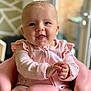 baby, infant, pink_clothing, smiling, happy, child, portrait, indoor, seat, hands, face, blue_eyes, cute, young_child, soft_lighting, closeup, sitting, furniture, cozy, background_blur