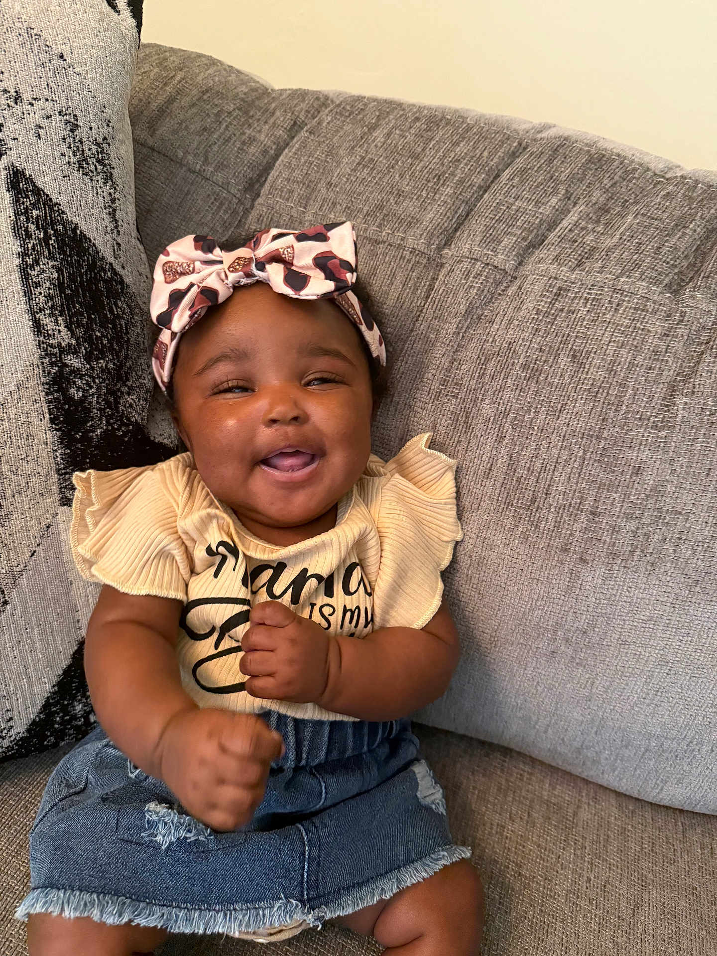 Denver joined the competition — help win amazing prizes! baby, child, smiling, headband, bow, denim_skirt, yellow_top, couch, furniture, happy, cute, indoor, portrait, person, clothing, sitting, infant, hands, skin, face