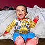 Ernest is registered to the contest to win money with this photo: baby, child, smiling, happy, indoors, clothing, colorful, cowboy, outfit, feet, toes, blanket, sitting, face, cute, portrait, person, expression, warm, cozy
