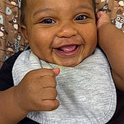 Casimir joined the competition — help win amazing prizes! baby, smiling, happy, infant, face, hand, clothing, bib, black_shirt, patterned_background, owl_pattern, cute, portrait, closeup, child, young, cheerful, indoors, skin, expression