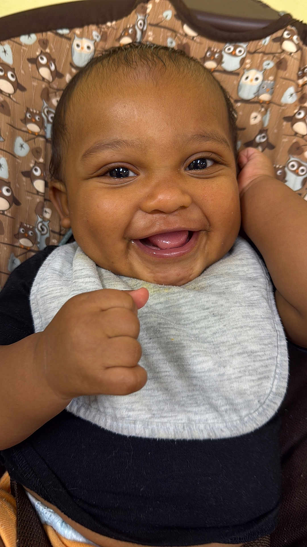 Casimir joined the competition — help win amazing prizes! baby, smiling, happy, infant, face, hand, clothing, bib, black_shirt, patterned_background, owl_pattern, cute, portrait, closeup, child, young, cheerful, indoors, skin, expression