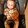 baby, car_seat, onesie, infant, child, clothing, seatbelt, safety, indoor, cute, portrait, childcare, vehicle_pattern, hands, face, head, bright_eyes, expression, hair, fabric