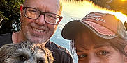 Ripp is registered to the contest to win money with this photo: man, woman, dog, smile, glasses, hat, lake, sunset, water, trees, outdoor, nature, portrait, happy, pet, animal, casual, people, reflection, scenic