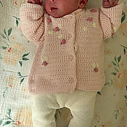 Laly a rejoint le concours — aidez-le/la à gagner de superbes lots ! baby, newborn, infant, child, blanket, floral_pattern, knitted_sweater, pink, pastel, lying_down, portrait, awake, hands_up, socks, knitted_pants, cute, bedspread, head, face, soft_textile