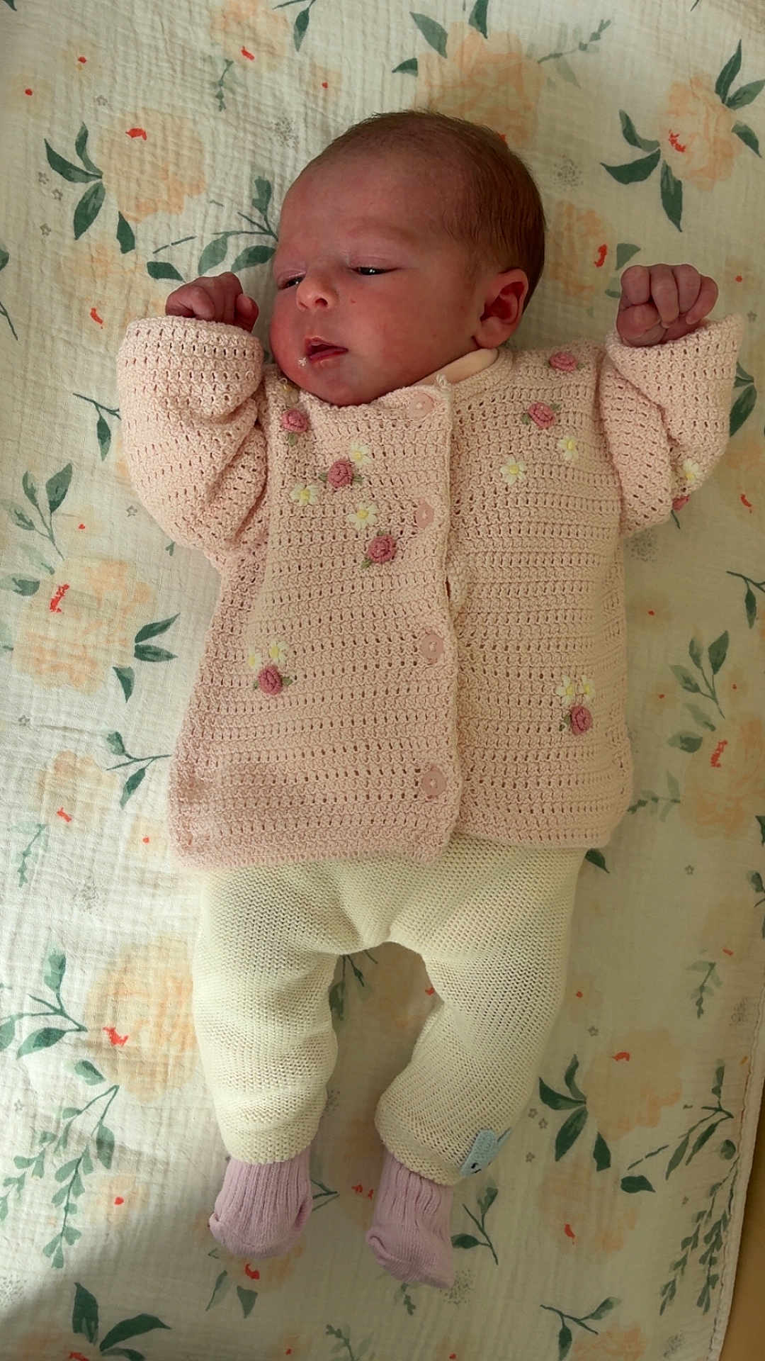 Laly a rejoint le concours — aidez-le/la à gagner de superbes lots ! baby, newborn, infant, child, blanket, floral_pattern, knitted_sweater, pink, pastel, lying_down, portrait, awake, hands_up, socks, knitted_pants, cute, bedspread, head, face, soft_textile