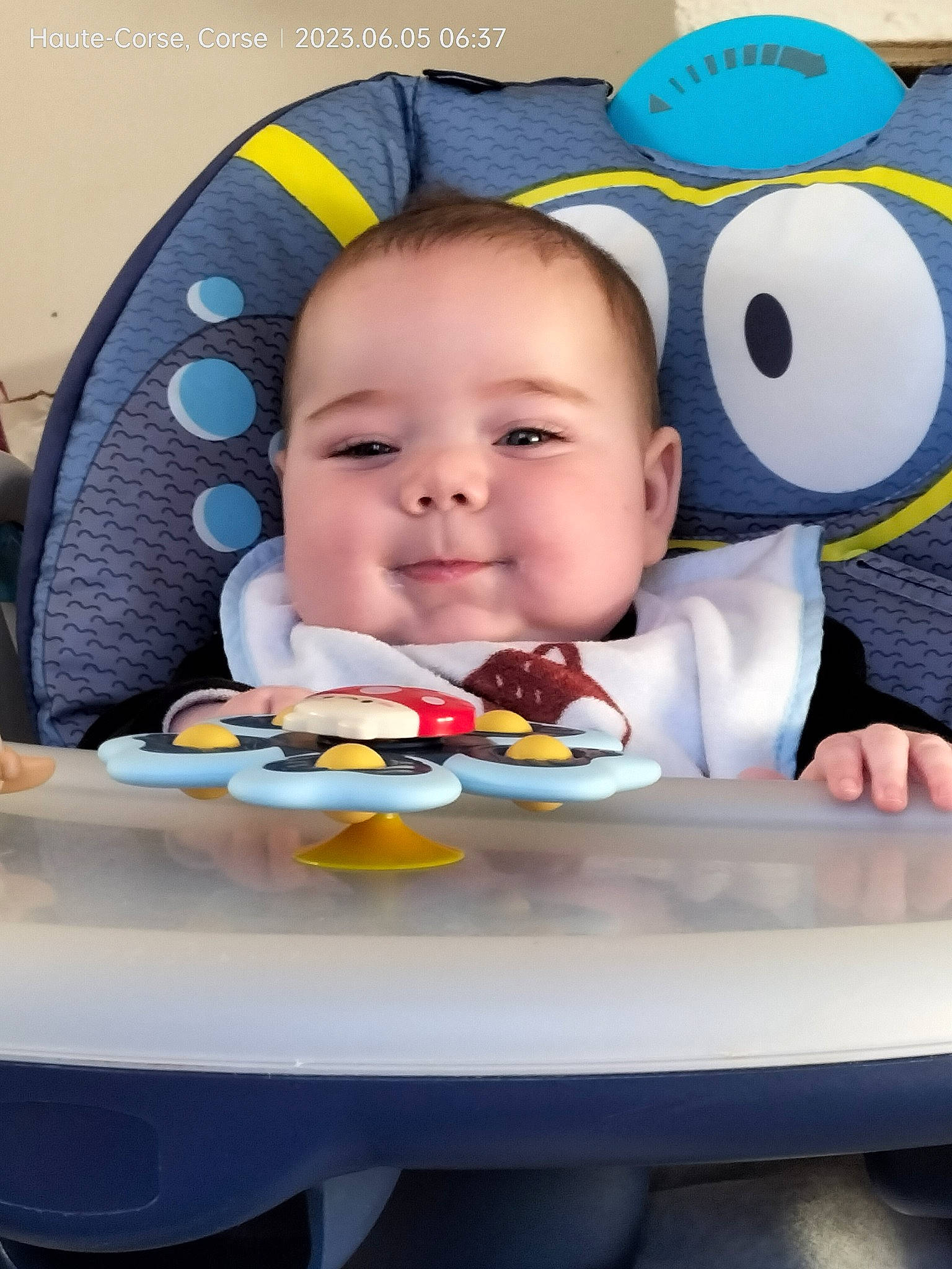 Dylan a rejoint le concours — aidez-le/la à gagner de superbes lots ! baby, baby_products, baby_toddler_clothing, bib, chair, child, comfort, comfort_food, fun, happy, joy, orange, person, product, sitting, skin, smile, stuffed_toy, table, toddler