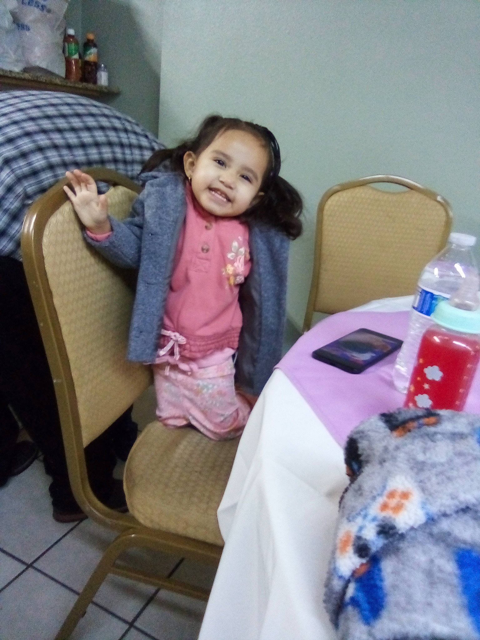 Karina is registered to the contest to win money with this photo: baby, baby_toddler_clothing, bottle, chair, child, comfort, drinking_water, event, flooring, fun, joy, linens, person, plastic_bottle, product, room, sitting, smile, t_shirt, table