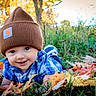 baby, child, smile, blue_shirt, brown_beanie, autumn, fall_leaves, grass, outdoor, nature, cute, portrait, happy, young_child, seasonal, sunlight, plaid, headwear, baby_face, laying_down