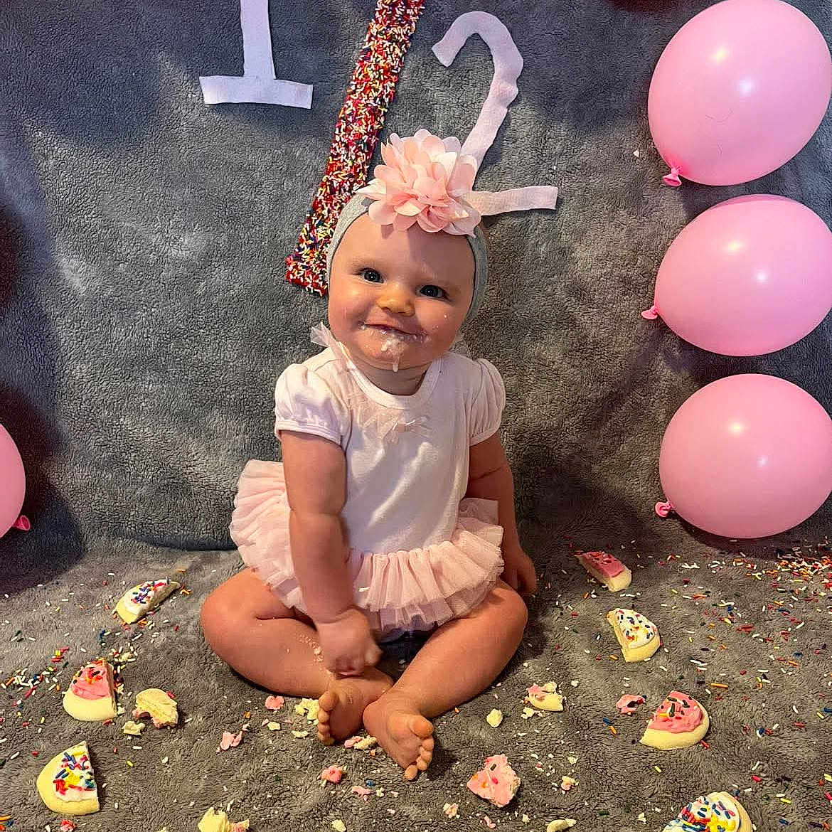 May'Lynn joined the competition — help win amazing prizes! baby, birthday, blanket, cake, celebration, child, cookie, crumbs, cute, first_birthday, flower, headband, indoors, messy, party, pink_balloon, sitting, smiling, sprinkles, tutu