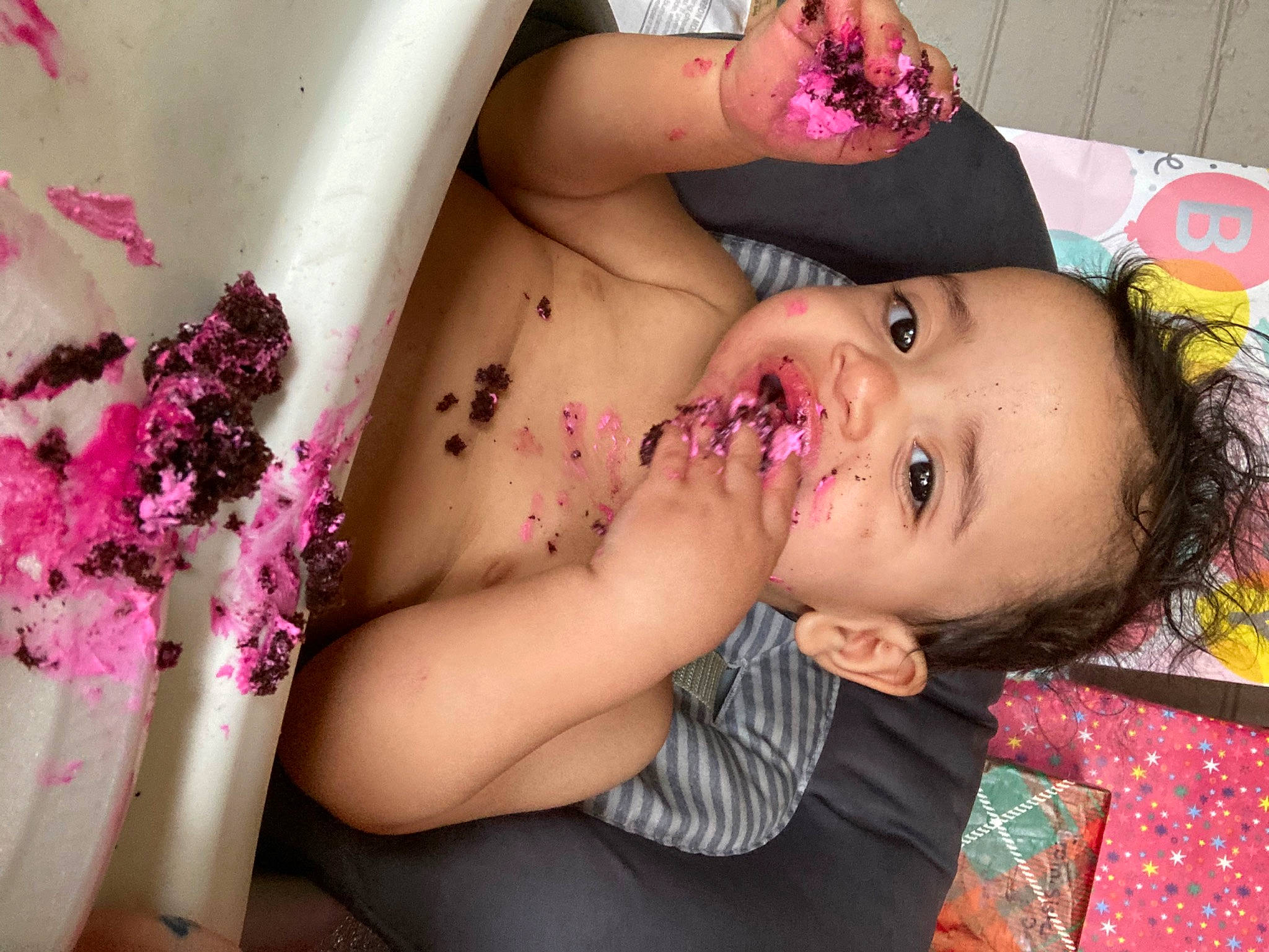 Alijah is registered to the contest to win money with this photo: abdomen, baby, black_hair, chest, eyelash, happy, headgear, headpiece, jewellery, lip, magenta, mouth, nail, person, petal, pink, plant, skin, temporary_tattoo, toddler