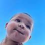 Julian Rodriguez is registered to the contest to win money with this photo: baby, face, necklace, skin, cheeks, expression, portrait, closeup, child, outdoor, blue_sky, neck, person, young, cute, smile, looking_up, sunlight, head, happy
