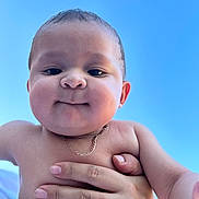 Julian Rodriguez joined the competition — help win amazing prizes! baby, child, face, skin, hand, necklace, outdoor, blue_sky, smile, person, human, young, infant, holding, cute, closeup, portrait, bare_chest, expression, support