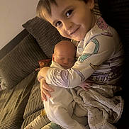 Caleb is registered to the contest to win money with this photo: baby, blanket, child, couch, cozy, cute, dinosaur, face, family, happy, holding, home, indoor, love, newborn, pajamas, siblings, sleeping, smile, toddler