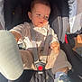 baby, car_seat, child, infant, footwear, shoe, straps, safety_harness, cute, clothing, pattern, bear, light, sunlight, expression, face, hand, leg, comfort, seat