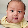 Nivaan Gurung joined the competition — help win amazing prizes! baby, infant, child, portrait, face, eyes, wide_eyed, looking_at_camera, yellow_shirt, clothing, sitting, cushion, indoor, home, close_up, head, hair, smiling, photography, watermark