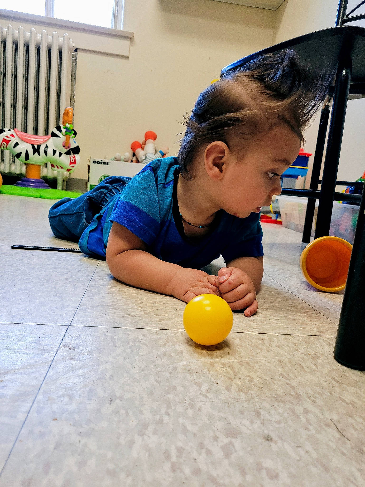 Nicolas a rejoint le concours — aidez-le/la à gagner de superbes lots ! baby_playing_with_toys, ball, chair, child, flooring, fun, hardwood, houseplant, kindergarten, learning, leisure, orange, person, play, room, sitting, t_shirt, toddler, toy, window
