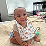 baby, child, smiling, bib, blanket, bed, indoor, window, crib, happy, person, infant, clothing, cute, foot, hand, bracelet, room, natural_light, sitting