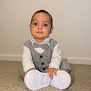 Liam is registered to the contest to win money with this photo: baby, child, infant, carpet, floor, white_shoes, bow_tie, gray_suit, pinstripe, sitting, indoors, portrait, cute, wide_eyes, hands, clothing, person, young, formal_wear, expression