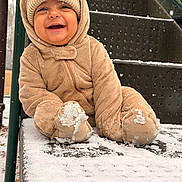 Liam is registered to the contest to win money with this photo: baby, child, snow, winter_clothing, snowsuit, hat, smile, playground, slide, snowfall, happy, cute, outdoor, cold_weather, infant, frozen, winter, clothing, person, joyful