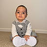 Liam joined the competition — help win amazing prizes! baby, child, indoor, carpet, white_shoes, gray_suit, bow_tie, sitting, curious, portrait, person, floor, wall, cute, fashion, formal_wear, young_child, hands, footwear, expression